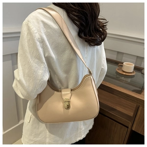 Detail of beige crescent shoulder bag with a gold twist lock and smooth faux leather