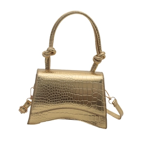 Chic gold crocodile texture handbag with unique curved base and knotted handle design