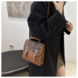 Detail der Vintage-Umhängetasche mit Leopardenmuster und doppelten Schnallenriemen aus Leder