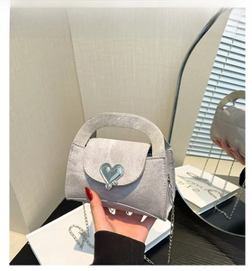 Detailed view of grey textured crossbody bag with large silver heart-shaped metal buckle