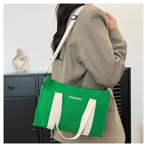 Détail du sac cabas en toile verte avec texte FASHION blanc et bandoulière réglable