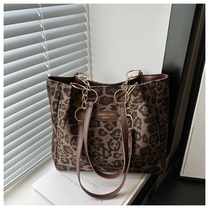 Detail of leopard print tote bag with leather logo tag and gold metal hardware