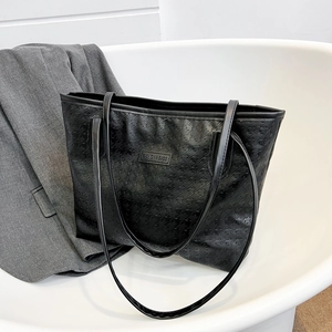 Black houndstooth embossed tote bag with long shoulder straps for trendy commuters