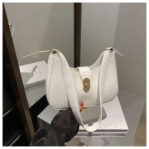 Detail of white crescent leather bag featuring a gold clasp and minimalist shoulder strap