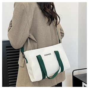 Détail d'un sac fourre-tout en toile blanche avec imprimé et bandoulière verte réglable