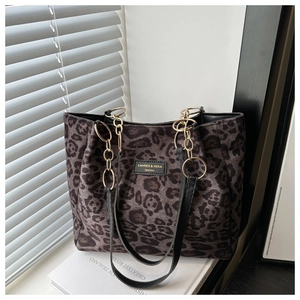 Detail of leopard print tote bag featuring gold chain strap and brand label