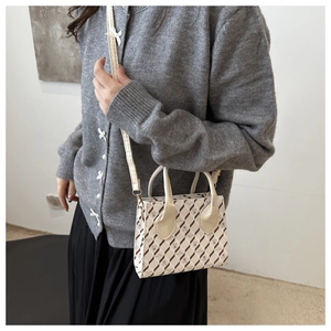 Petit sac à bandoulière rétro à carreaux avec motif ours porté sur un pull gris