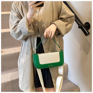 Dettaglio borsa a tracolla verde e beige in pelle e tela con ampia tracolla regolabile