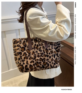 Chic leopard print plush tote bag with brown leather handles shown on a model