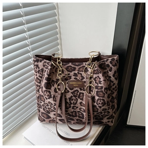 Detailed view of leopard print tote bag with metal chain strap and brand leather patch