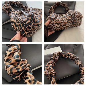 Détails du sac à main léopard montrant l'anse froncée et la texture du cuir plissé