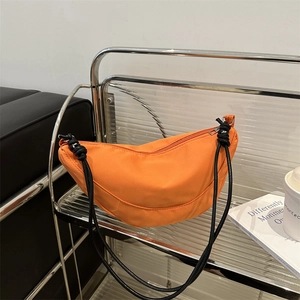 Minimalist bright orange nylon crescent crossbody bag with black braided rope straps