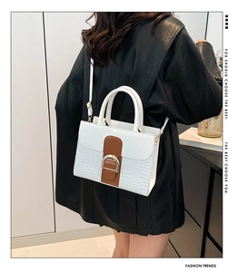 Détail du sac à main blanc gaufré crocodile avec lanière brune et boucle dorée chic