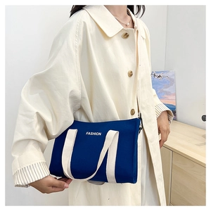 Détail du sac fourre-tout en toile bleu marine avec poignées et lettrage FASHION blanc