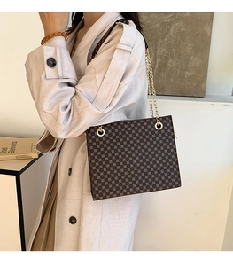 Brown vintage crossbody tote bag with geometric print and gold chain strap on model