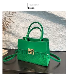 Dettaglio borsa a mano verde con trama a coccodrillo e fibbia in metallo dorato lucido