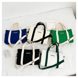 Détail de sacs cabas en toile en cinq couleurs avec imprimé FASHION et bandoulière