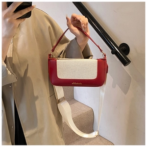 Dettaglio della borsa vintage bicolore con trama in tela e finiture in pelle rossa