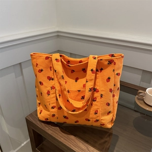 Orange corduroy tote bag with strawberry print and spacious casual shoulder design