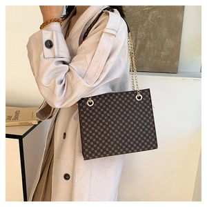 Detailed view of brown retro pattern tote bag with gold chain strap on a model