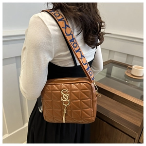 Sac bandoulière matelassé caramel avec pompon doré et large bandoulière à motifs variés