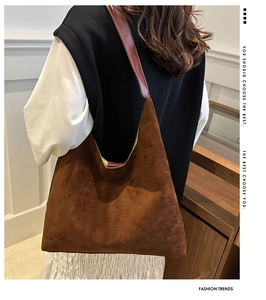 Brown matte suede tote bag with leather strap shown in a minimalist interior setting