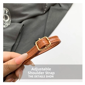 Détail d'une bandoulière réglable en cuir marron avec boucle en métal doré pour sac à main