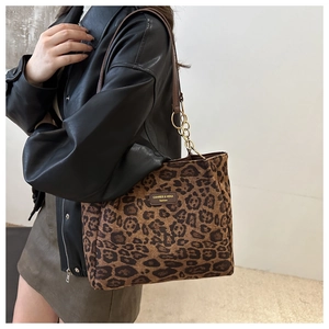 Detail of retro leopard print tote bag with brown leather strap and metal ring