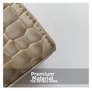Dettaglio della trama in pelle di coccodrillo e cuciture fini su una borsa beige