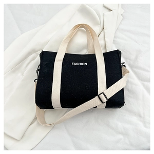Detail of contrast canvas tote bag with FASHION print and adjustable shoulder straps