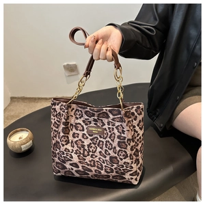 Détail du motif léopard et de la plaque de marque sur un sac cabas élégant et moderne