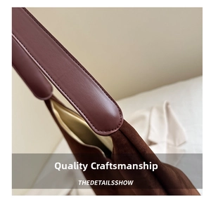 Macro detail of retro suede tote bag showing brown leather strap and fine stitching