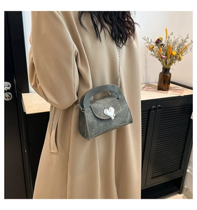 Gray vintage textured crossbody bag with silver heart buckle shown on a shoulder
