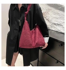 Détail d'un sac à bandoulière en daim bordeaux avec bandoulière nouée décorative
