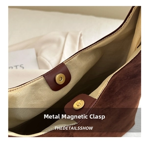 Close-up of golden magnetic snap button on brown suede tote bag with textile lining