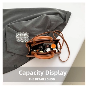 Vue intérieure montrant la grande capacité du sac en cuir marron avec accessoires quotidiens