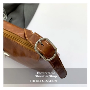 Detail of adjustable shoulder strap on brown vintage bag with silver buckle and stitching