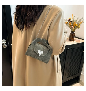 Chic grey-green crossbody bag with heart metal buckle and chain strap on model