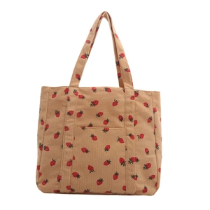 Brown corduroy tote bag with red strawberry print and front pocket on white background
