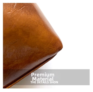 Close-up of premium brown oily leather texture with neat stitching on a vintage square bag