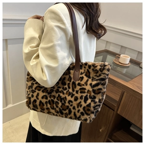 Detailed view of leopard print plush tote bag with dark brown straps worn by model