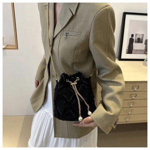 Details einer schwarzen Stepp-Beuteltasche mit Perlenzugband und goldener Kette