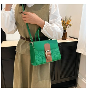 Détail du sac à main vert en similicuir avec motif crocodile et boucle fer à cheval