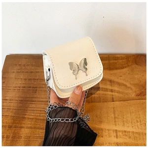 Détail d'un mini sac blanc avec motif crocodile et fermoir papillon en métal argenté