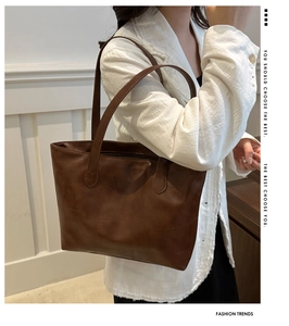 Detail of dark brown tote bag with geometric embossed texture and vintage leather finish