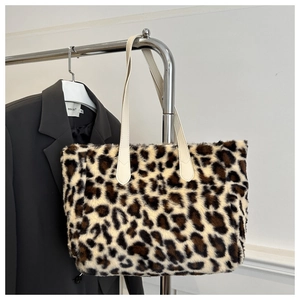 Detailed close-up of leopard print faux fur tote with white leather handles on a hanger