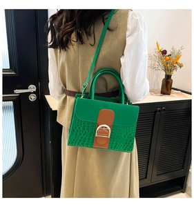 Detailansicht der grünen Krokoprägung-Handtasche mit D-Verschluss und Lederriemen
