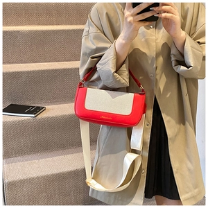 Dettaglio borsa a tracolla rossa e crema con trama intrecciata e logo dorato