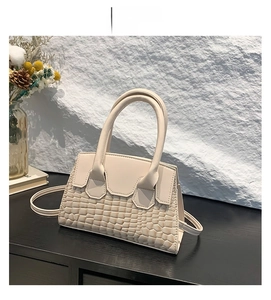 Dettaglio borsa a tracolla bianca con elegante trama a rilievo stile coccodrillo