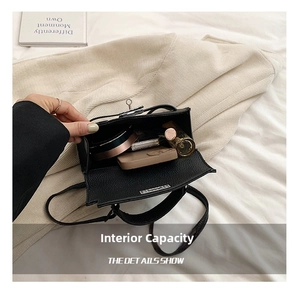 Detail shot of the black litchi texture handbag showing interior capacity for essentials
